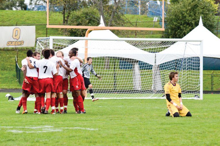 The Carleton Ravens celebrate their second goal in front of Gaels' midfielder Nick Pateras at Richardson Stadium on Saturday.