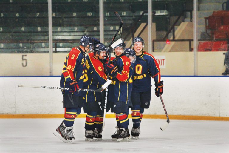 The men's hockey team celebrates forward Kelly Jackson's winning goal during the third period against the Carleton Ravens on Friday.