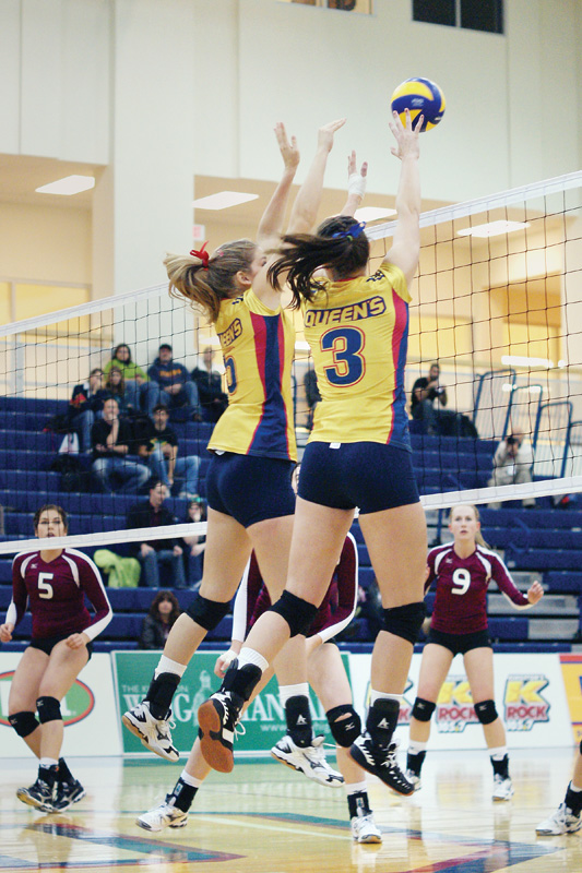 Women's volleyball players go up for a block during their straight-set win over the McMaster Marauders on Saturday night.