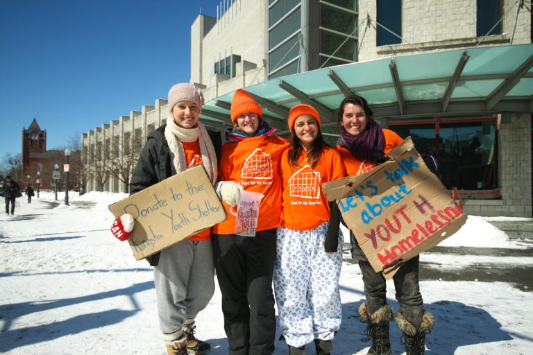Volunteers stand outside of Stauffer Library to raise awareness about homeless youth.