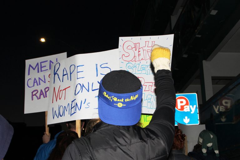 Protestors at Take Back the Night hold up signs