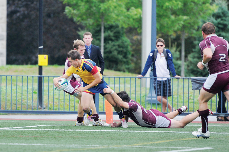 Liam Underwood fights off a tackle to score a try against McMaster on Nov. 5