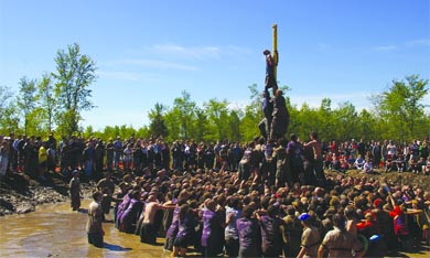 Hundreds of engineering students work together to retrieve a tam from atop the Grease Pole.