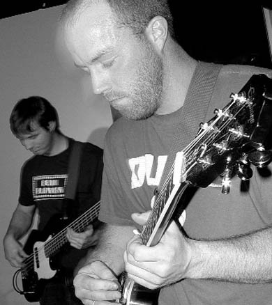 Two members of Grand Theft Bus deliver a few riffs at Elixir.