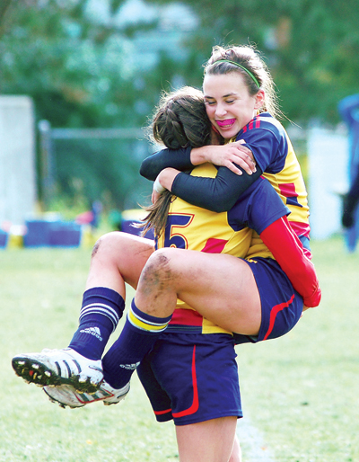 The women’s rugby team celebrates their 15-8 win over the Waterloo Warriors in Kingston.