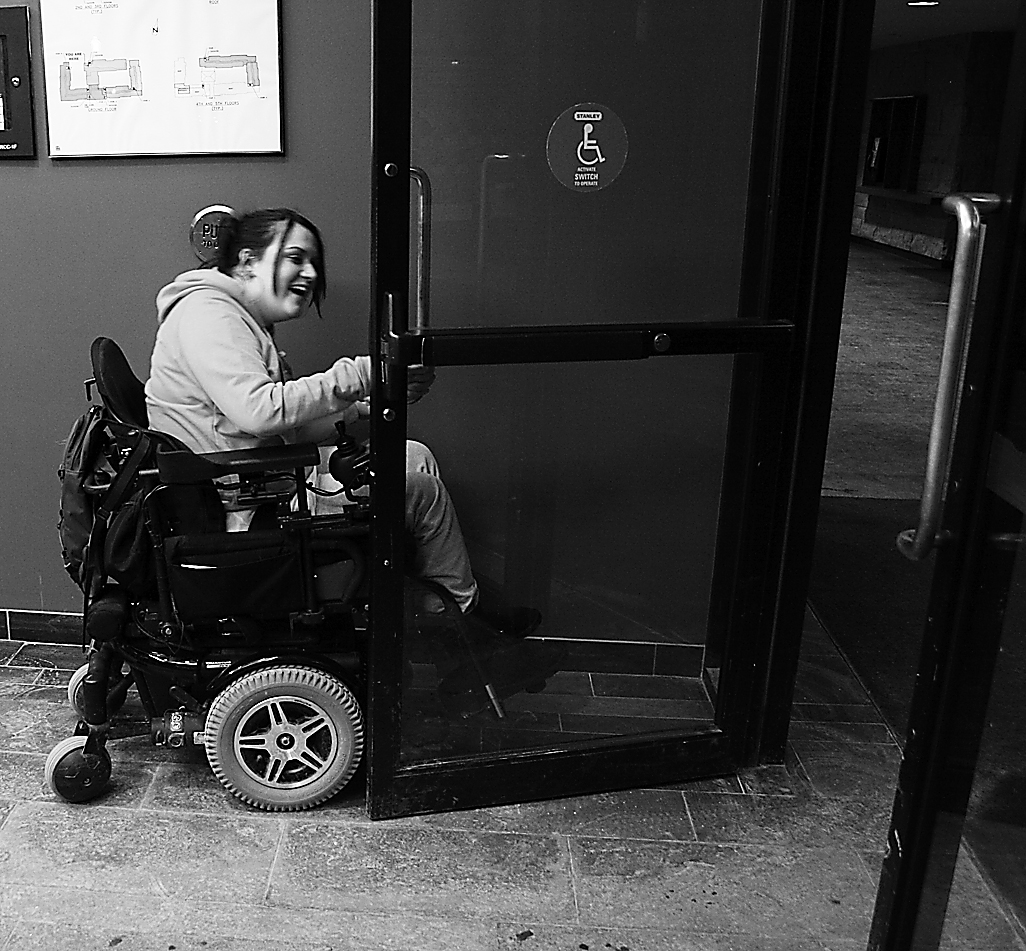 Katie Charboneau demonstrates the difficulties caused by poorly placed door openers.
