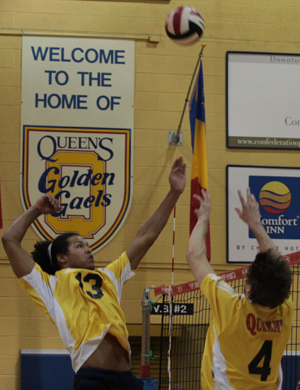 Devon Miller (4) sets Queen's rookie middle hitter Michael Amoroso up for a kill against Ryerson Saturday night in Bartlett Gym.