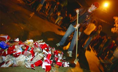 Municipal Affairs Commissioner Ryan Quinlan-Keech cleans up discarded cups on Aberdeen Street early Sunday morning.