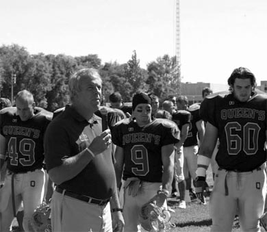 Pat Sheahan addresses the crowd as captains (from left to right) Mike Patone