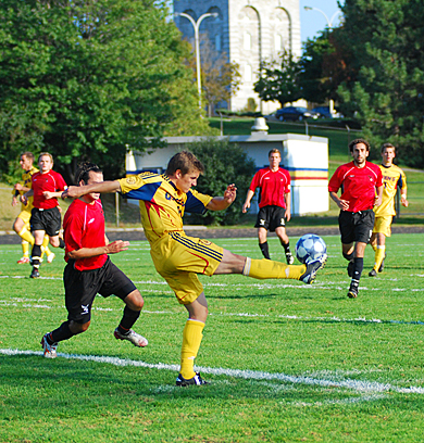 Gaels’ midfielder Mike Arnold clears the ball away from Carleton’s Matthew D’Angelo Wednesday. Queen’s lost 2-1.
