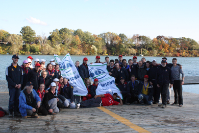 The men’s and women’s rowing teams pose with their OUA championship banners on the dock in St. Catharines Saturday.