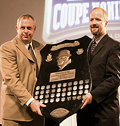 Queen’s football head coach Pat Sheahan (left) accepts the Frank Tindall Trophy Friday.