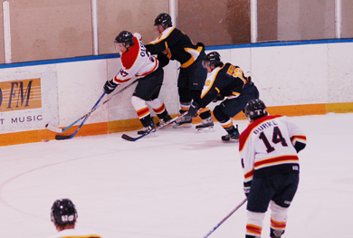 Former Queen’s forward Brady Olsen battles a Ryerson Rams’ defender for the puck in a Feb. 9