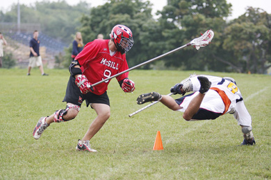 The Gaels’ Torey Kohara is taken down by McGill defender Jonathan Zimmerman in Saturday’s lacrosse match at North Field. The Redmen beat Queen’s 9-8 on a last-second goal.