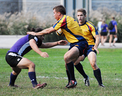Queen’s flanker Alistair Clark eludes a Western tackler Saturday as outside centre Zach Pancer looks on. The Gaels tied the Mustangs 12-12 thanks to a late try from Pat Richardson.