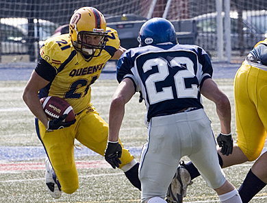 Gaels’ running back Mike Giffin tries to juke past Toronto defensive back Derek Batchelor Saturday. Queen’s won 58-14.