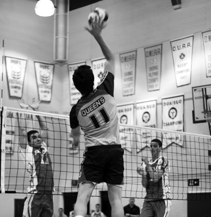 Outside Brett Walter spikes during Queen’s straight-set victory over RMC.