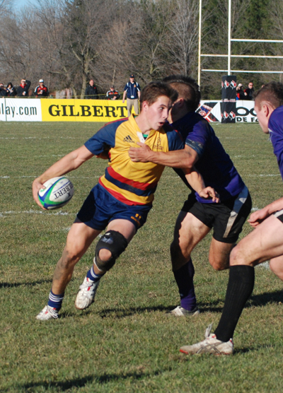 Scrum-half Liam Underwood pushes through a Mustang tackle during the men's rugby team's 23-19 Turner Trophy victory at Fletcher's Field on Saturday.