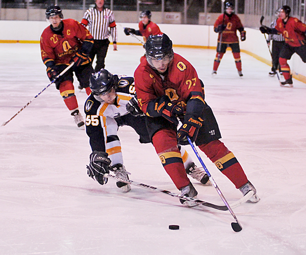 Gaels forward Brock Ouellet avoids the challenge of Windsor defenceman Jeff Broderick during Friday’s 7-5 loss at the Memorial Centre.