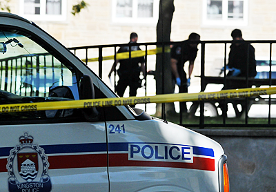 Kingston Police investigate the scene of a deceased student behind Victoria Hall yesterday morning.